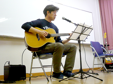 一人でアコースティックギターの弾き語りをする生徒さん（40代男性）の写真