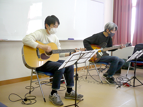 40代男性の生徒さんと講師のギター演奏を別の角度からの写真