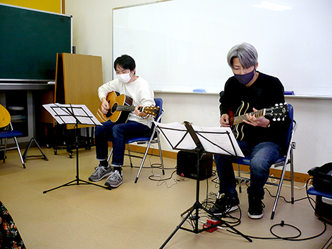 40代男性の生徒さんと講師のギター演奏の様子