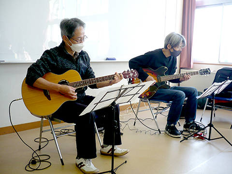 60代男性の生徒さんと講師のギター演奏の様子